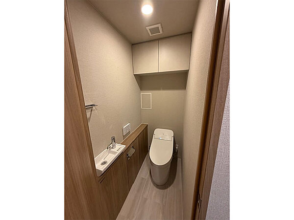 【トイレ】独立手洗い器が備わっているトイレです。吊り戸棚が設置されいるため、トイレットペーパーのストックなど収納可能です。