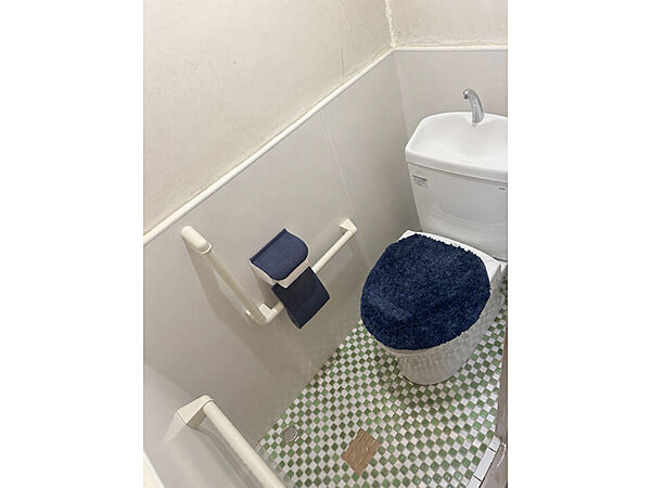 【トイレ】トイレは洗面室に隣接しています。立ち上がりをサポートしてくれるL字型の手すりが設置されています。ご高齢の方や小さなお子様も使い勝手がよさそうです。(2026年6月撮影)