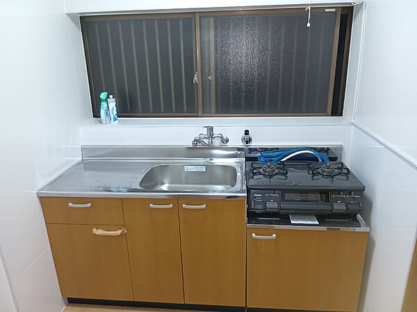 【キッチン】2口ガスコンロ仕様のキッチン。下部に収納スペースが備わっており、調理器具・食器などをまとめて収納していただけます。