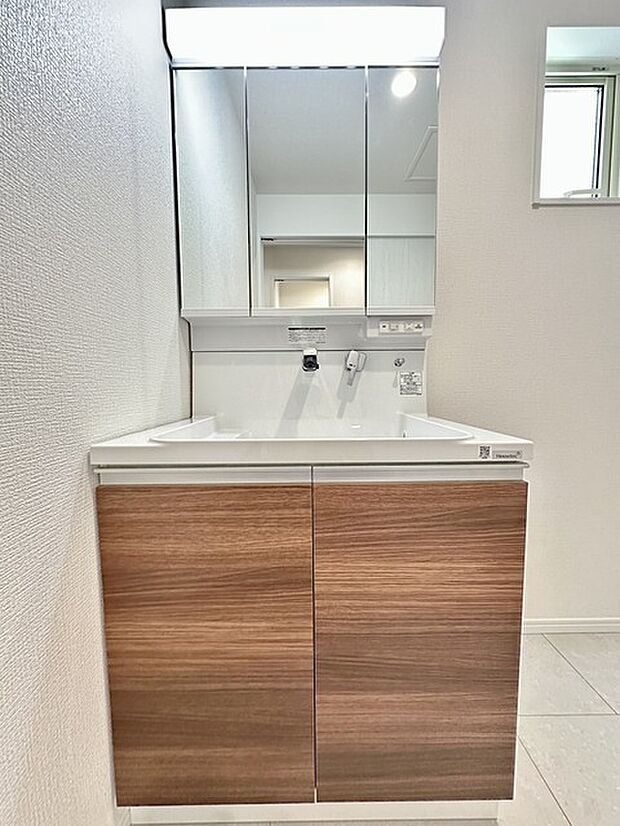 ゆとりの洗面スペースで朝の身支度も快適スムーズに。三面鏡で髪のセットやお化粧もストレスなくこなせ、朝から気分上昇！ 三面鏡の背面とシンク下の収納もたっぷり！アメニティ類のストックもバッチリ！ 