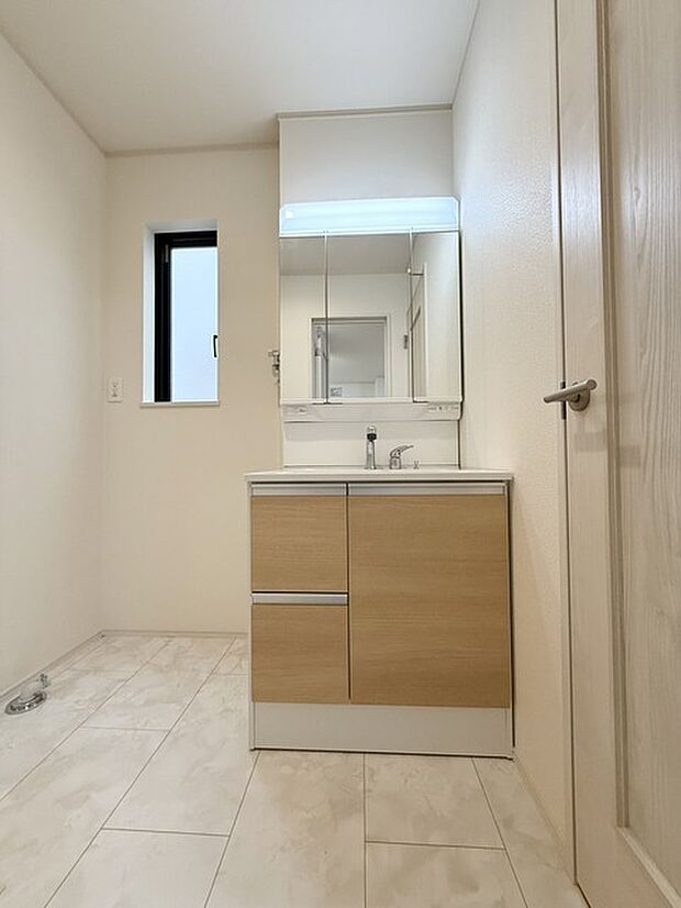 ゆとりの洗面スペースで朝の身支度も快適スムーズに。三面鏡で髪のセットやお化粧もストレスなくこなせ、朝から気分上昇！ 三面鏡の背面とシンク下の収納もたっぷり！アメニティ類のストックもバッチリ！ 