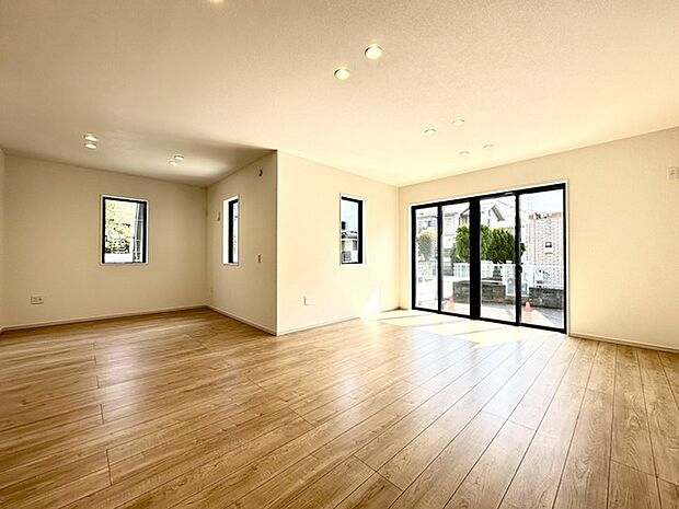 広々とした空間に、温かみのある床材が心地よい穏やかな印象を与えます。窓の外の緑が目に優しく、ゆとりある暮らしを予感させる、明るく開放的な住まいです 