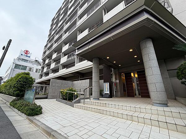 存在感のある2本の円柱と、深いキャノピー（庇）が目を引く洗練されたアプローチ。