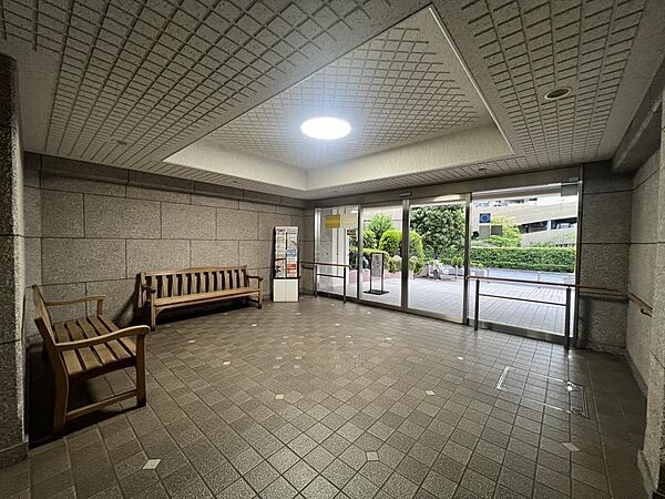 木調ベンチが配されたゆとりあるエントランスホール