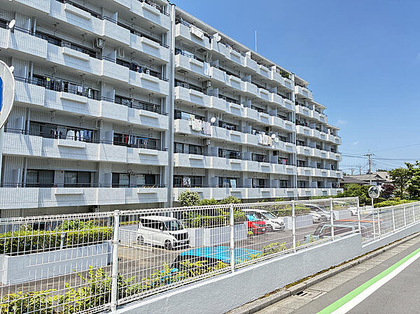 敷地が広く、開放的な印象を与える外観。手前には整理された駐車場・駐輪場スペースもございます。