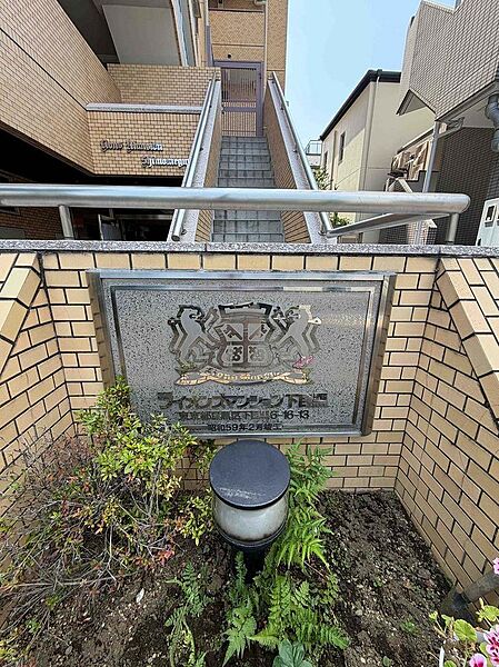 緑を配したシックで高級感のある館銘板。マンションの顔として品格を漂わせます。