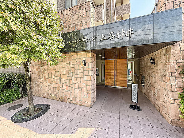 高級感のある重厚な石造りのエントランスアプローチ。青々とした植栽が美しく彩りを与えます。