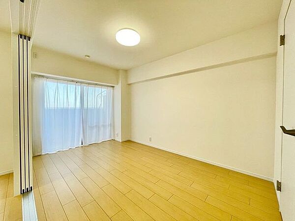 大きな窓から陽光が降り注ぐ明るい洋室