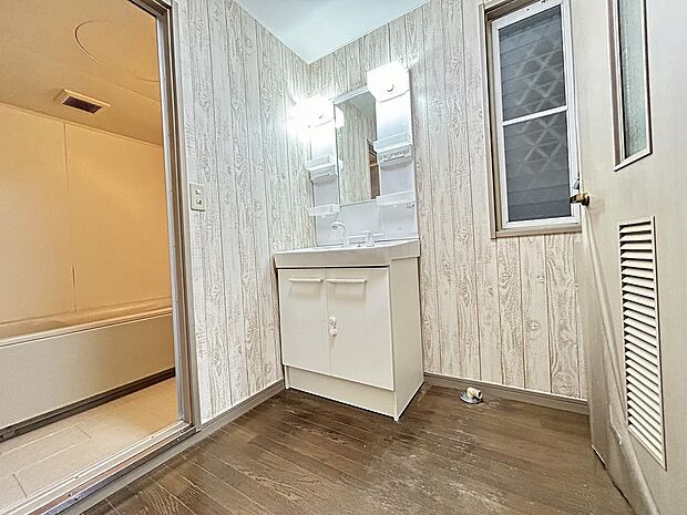 木目調の壁紙がかわいい洗面室です。隣には納戸もあるので、動線ばっちりです！