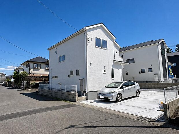 1号棟外観。駐車スペースを備え、車利用の多いご家庭にも便利な住まいです。