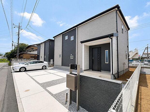 2号棟の外観。落ち着いた建物デザイン、広々駐車スペース