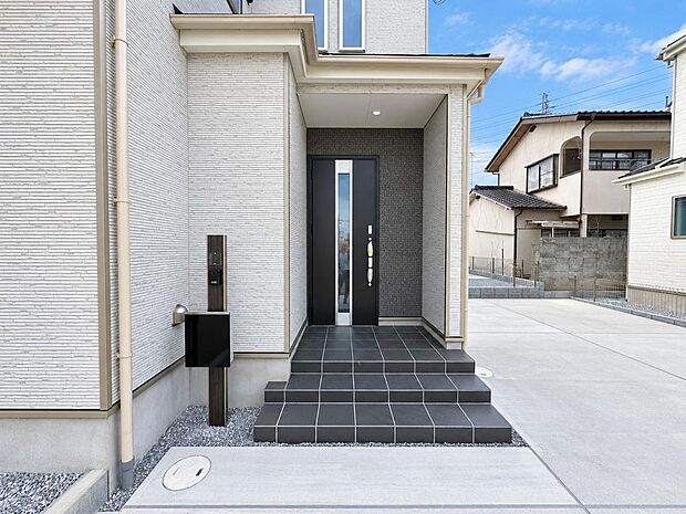 B号棟 手すり付きの玄関アプローチ。段差の上り下りがしやすく、毎日の出入りを支えます。