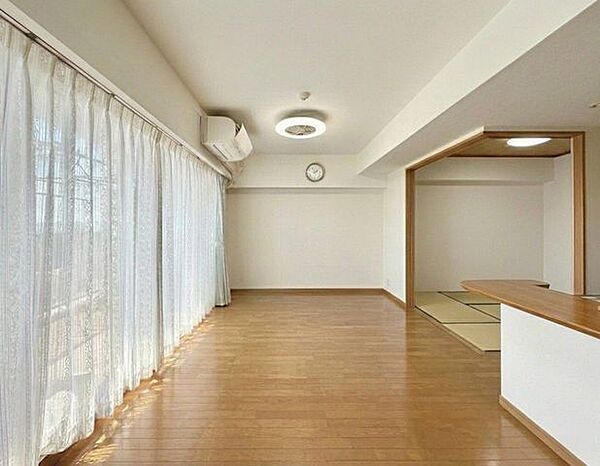 リビング（写真は家具撤去後→AI加工）、写真では伝わらない空間の広さを、現地でご体感ください