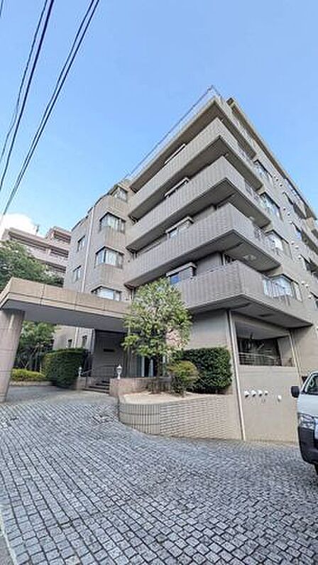 見上げる構図で建物の伸びやかさが伝わる外観写真。角地らしい開放感と整った植栽が印象的で、帰宅のたびに気持ちが整うアプローチです♪