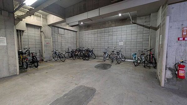 屋内駐輪場の写真。雨にさらされにくい共用スペースで、自転車移動が多いご家族も使いやすく、毎日の通勤通学をすっきり支えてくれます！