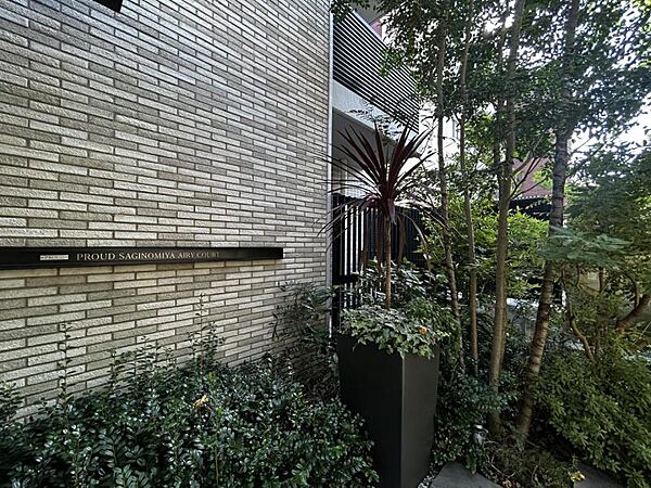 【エントランス】タイル壁に美しく映える、モダンなデザインのマンションサイン。
