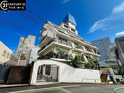 外観：【外観】青空に映える重厚な佇まい。都心の喧騒を忘れさせる端正な外観。