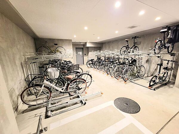 屋内型の駐輪場は、天候の影響を受けにくく、雨の日も安心して利用可能。自転車用2段式ラックに加え、バイク置場も設けられており、幅広い移動手段に対応した共用空間です
