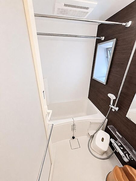 落ち着きのある木目調アクセントパネルが上質な雰囲気を演出する浴室。浴室換気乾燥機とランドリーパイプを備え、雨の日の洗濯にも便利です。清潔感ある空間で、毎日のバスタイムを心地よくお楽しみいただけます。