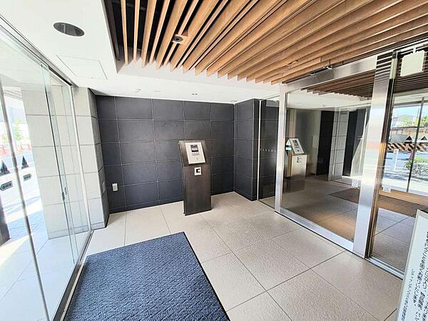 木目天井とダークカラーの壁面が印象的なエントランスホール。洗練されたデザインが、落ち着きと上質感を演出します。