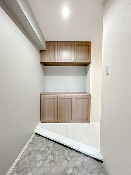 【リフォーム済】玄関は土間を長尺シート上貼り、シューズボックスのクリーニング、照明交換、クロス張り替えを行いました。