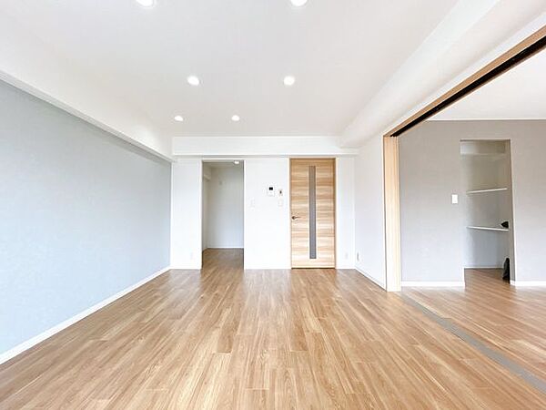 【リフォーム後】リビングはクロス張替え・床張り替え・照明交換を行いました。東側の洋室を開放して広々使うことも可能です。