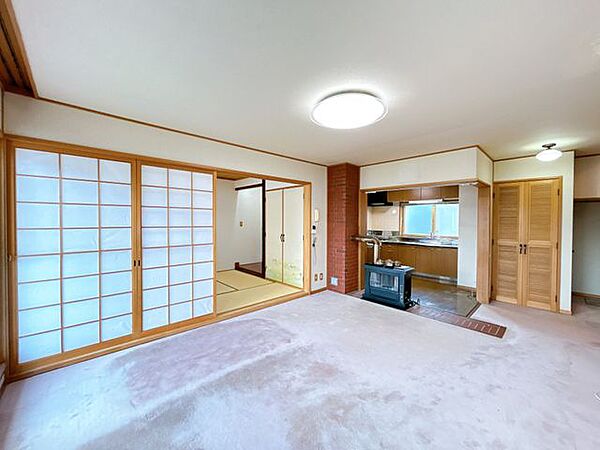 【リフォーム中＿リビング】リビングの別角度の写真です。クロス貼替、フロアタイル張替、照明交換等リフォーム予定です。2013年に前所有者様がペチカストーブから灯油ストーブに交換しております。