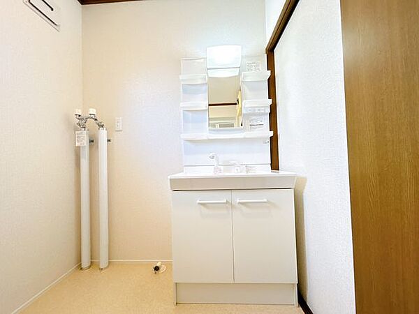 【リフォーム後】洗面脱衣室の写真です。洗面化粧台交換、床のクッションフロアの張替、壁天井のクロスの貼替を行いました。