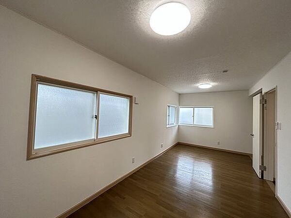 2階10.5帖洋室別角度の写真です。二面採光の明るいお部屋になっています。ドアが2か所あるので、仕切って使うことも可能です。