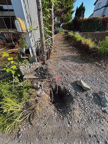 【境界】測量中です。西側隣地との境界のお写真です。売主にて建物解体と木の伐採を行い、整地にしてお引渡しいたします。