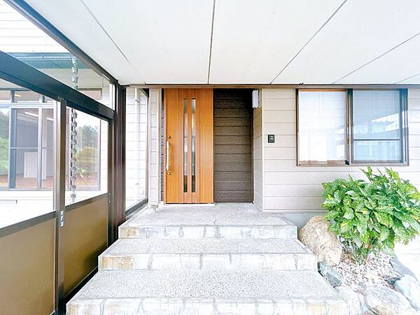 【リフォーム済／玄関】玄関扉をドアに新品交換しました。引き戸タイプで横にスライドして開けます。温かみを感じさせる、カジュアルな木目調の玄関ドアです。