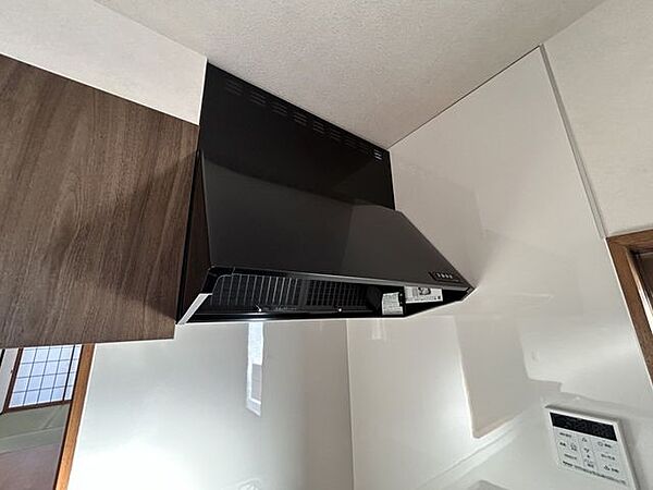 【リフォーム完成済み】新品キッチンの換気扇はスタイリッシュでスリムなフードです。力強く空気を外に押し出すファンを搭載したブラックフードです。40Wの照明付きです。