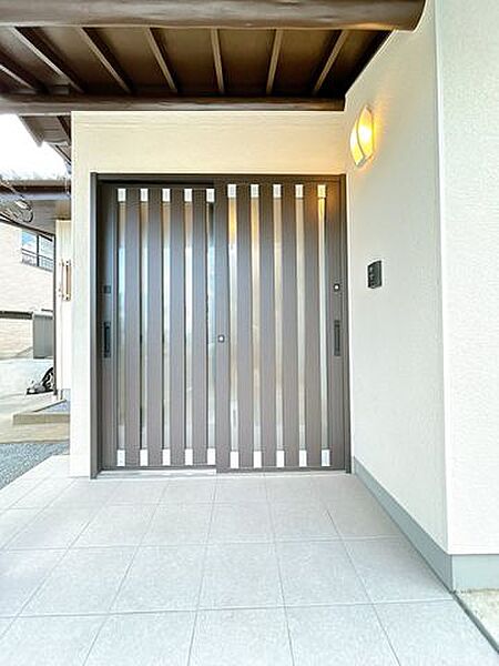 【リフォーム済】玄関です。玄関ドア交換、玄関タイル重貼、クロス貼替、照明交換を行いました。お家の顔となる玄関は明るく仕上げます。