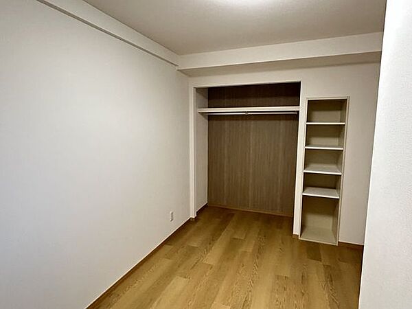 【約5帖洋室別角度】オープン収納スペースに収納棚が備え付けております。