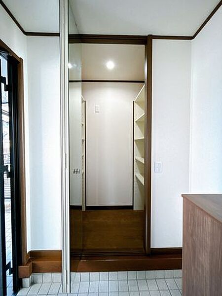 【リフォーム済】靴をたくさん収納できる、使い勝手のいいシューズクロークです。壁と天井のクロスを貼り替え、照明は交換しており、明るく清潔感のある空間に仕上がっています。折れ戸はミラー仕様のため、お出か…