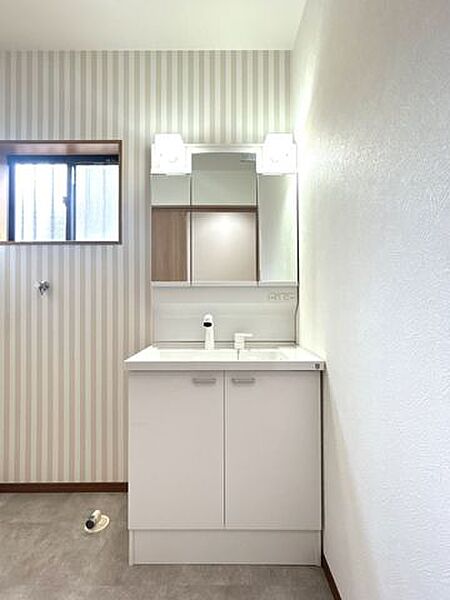 【リフォーム済】洗面室です。洗面化粧台は交換、壁天井はクロス貼り、床はクッションフロアを貼りました。奥の面に洗濯機と洗面台が並んで置けるような仕様です。