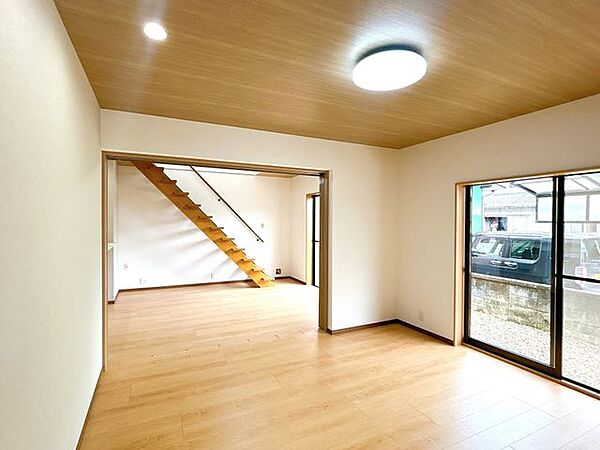 【リフォーム済】1階和室は洋室です。床はフローリング張り、壁天井はクロスを貼りました。LDKと居室の間に三枚戸を設置することで、1つの居室としても、約22帖の広いLDKとしても使用いただけます。