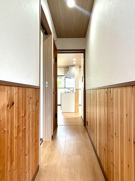【リフォーム済】1階廊下です。腰板は一部張替えを行いました。天井と一部壁はクロスを貼りました。床はフローリングを貼るりました。
