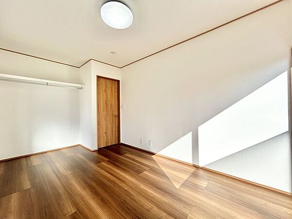 【リフォーム済】1階南西側洋室約6帖　収納はオープン収納に変更し、枕棚とハンガーパイプを設置しました。
