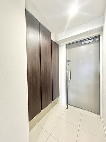 【リフォーム済販売】玄関（内観）　玄関はシューズボックスクリーニング、天井と壁のクロス張替え、床タイルクリーニング、照明交換を行いました。