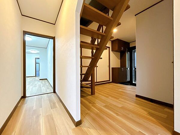 【リフォーム済写真】【階段・玄関ホール】広々として玄関ホールとL字型の階段です。階段に壁を作らないことで、玄関ホールを開放的な空間に仕上げられています。