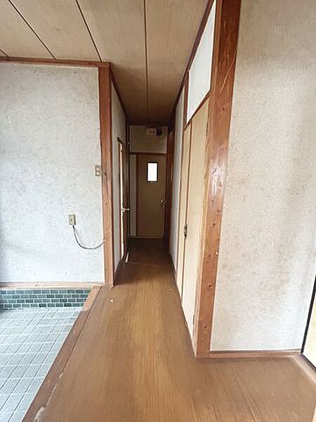 【リフォーム前写真】1階廊下写真。天井・壁のクロスを張替え、床はフロアタイルで重ね張りを行います。