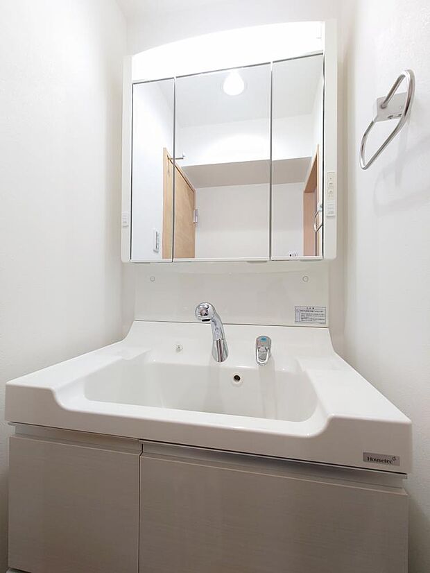 【リフォーム済】洗面所の写真です。洗面台はクリーニング、クロス、クッションフロア張替を行いました。三面鏡の洗面台は収納がすっきりできて嬉しいですね。洗面台は2018年に交換しております。