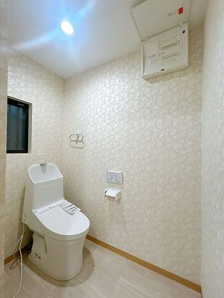 【リフォーム済】1階トイレの写真です。トイレは温水洗浄機能付きに新品交換します。表面は凹凸がないため汚れが付きにくく、継ぎ目のない形状でお手入れが簡単です。
