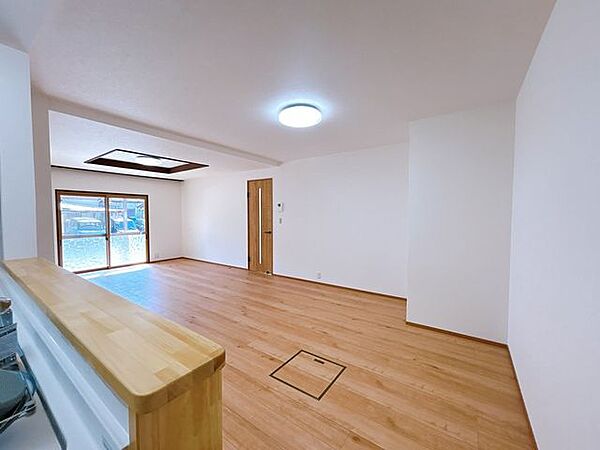 【リフォーム済】リビングです。クロスとフローリングの重ね張りを行いました。対面キッチンなので、ご家族とのコミュニケーションを楽しみながら料理ができそうです。