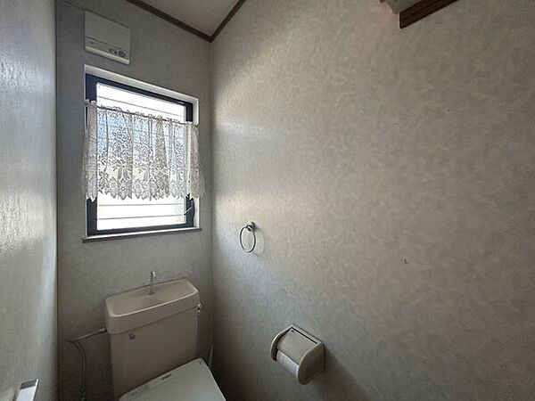 【トイレ】すっきりとしたトイレ空間。上部棚付きで、収納スペースもしっかり確保されています。