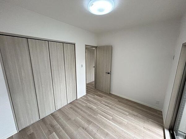 【リフォーム済】洋室約5.2帖の写真です。フローリング張替え、天井・壁クロスの張替えを行いました。照明器具がついています。