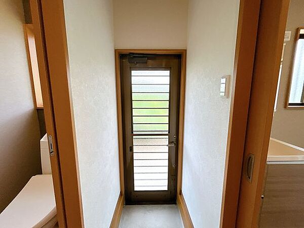 【リフォーム済み】勝手口の写真です。天井壁クロス張り、洗面化粧台交換、脱衣所床クッションフロア張り、鍵交換、照明交換等を行いました。