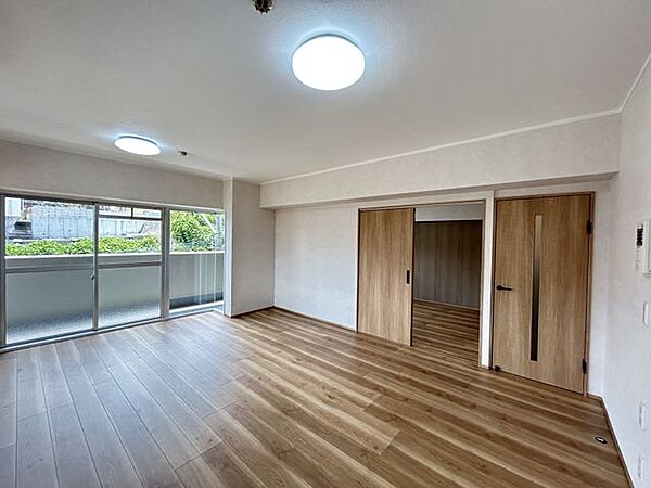 【リフォーム済】角部屋で、リビングは南側と東側バルコニーに面した日当たりのよい部屋です。和室との間にあった収納壁を解体して拡張しました。