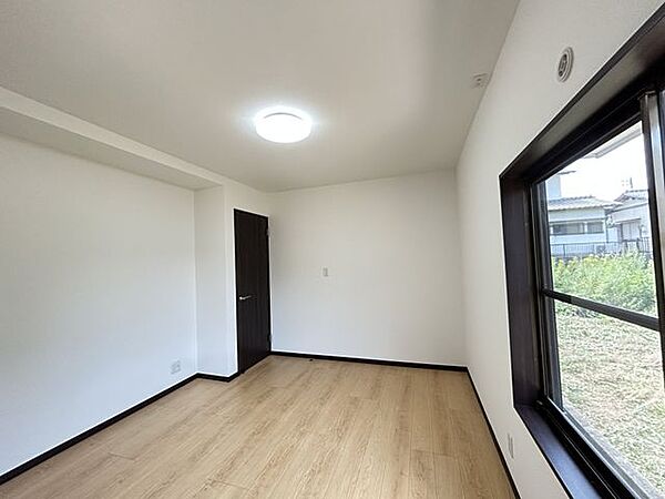 【リフォーム済】北側　6.8帖洋室の写真です。和室から洋室に変更しました。照明・建具は交換、コンセントも新設しています。